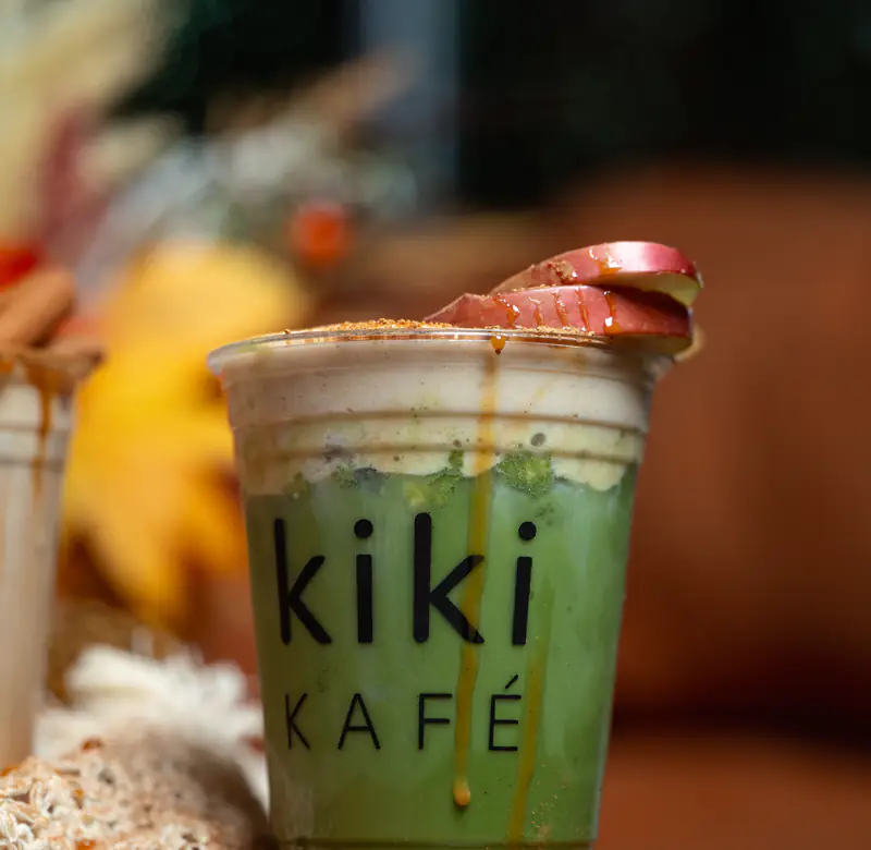 Caramelized apple matcha with yellow fall leaves at Kiki Kafé