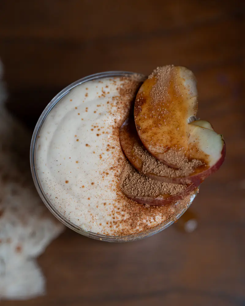 Top-down view of cinnamon-dusted foam with caramelized apple slices at Kiki Kafé