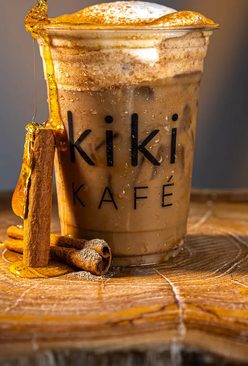 Iced latte with cinnamon foam, honey drizzle and cinnamon sticks