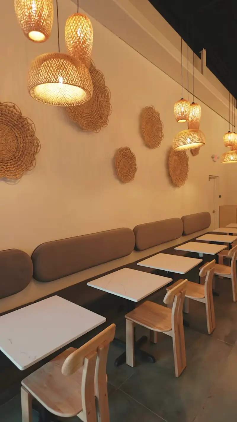 Banquette seating, wood chairs and pendant lights inside Kiki Kafé coffee shop, Clinton Township